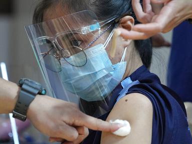 Seorang petugas kesehatan disuntik dengan vaksin COVID-19 Pfizer di National Kidney and Transplant Institute, Quezon City, Filipina, 17 November 2021. Pemerintah Filipina mulai menyuntikkan booster vaksin COVID-19 kepada pekerja garis depan. (AP Photo/Aaron Favila)