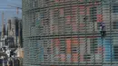 Pendaki pencakar langit, Alain Robert, yang juga dikenal sebagai 'Spiderman Prancis' memanjat Menara Agbar setinggi 144 meter di Barcelona, Rabu (4/3/2020). Aksi itu untuk menyerukan pemerintah dan individu di dunia agar lebih bertanggung jawab dalam menghadapi virus corona COVID-19 (LLUIS GENE/AFP)