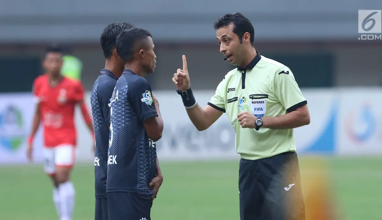 Wasit asal Iran, Bonyadifard Mooud (kanan) memberi peringatan pada pemain PSM Makassar saat laga melawan Persija di Stadion Patriot Candrabhaga, Bekasi, Selasa (15/8). Laga berakhir imbang 2-2. (Liputan6.com/Helmi Fithriansyah)
