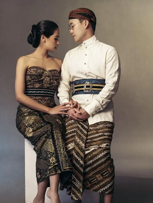 Momen pre-wedding Maudy Ayunda dan Jesse dengan balutan busana pengantin adat Jawa yang klasik. Maudy anggun dibalut kain kemben klasik tahun 1930, dipadu kain motif bunga prada emas tahun 1960 dan kain tenun Sumba yang diikatkan di pinggang. Jesse gagah mengenakan kemeja dengan beskap berwarna tanah dan ikat pinggang dari tenun Tanimbar, dihiasi pending emas antik, dibalut dengan batik motif Udan Liris. [Foto: Instagram/svarna_byikatindonesia]