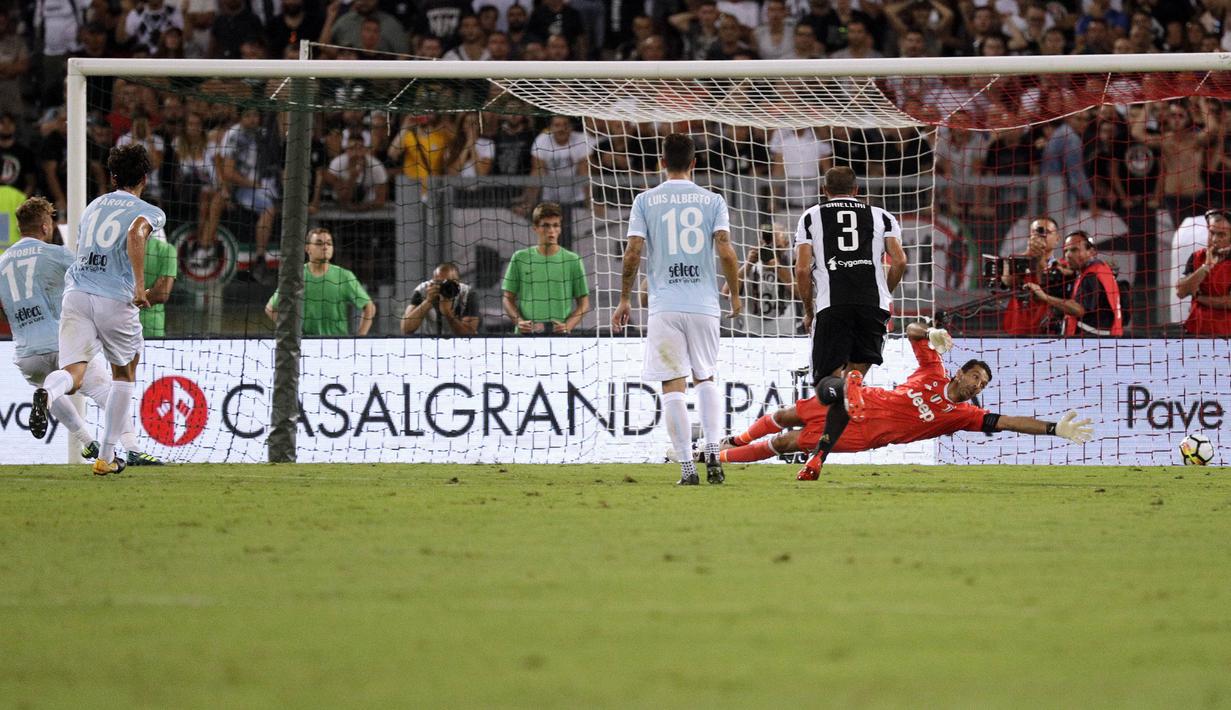 Striker Lazio, Ciro Immobile, mencetak gol ke gawang kiper Juventus, Gianluigi Buffon, lewat titik penalti pada laga Supercoppa Italiana 2017  di Stadion Olimpico, Minggu, (13/8/2017). Lazio menang 3-2 atas Juventus. (AP/Gregorio Borgia)