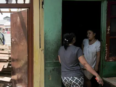 Warga bukit Duri berbincang di rumah yang sebagian telah dibongkar oleh Pemprov DKI Jakarta, Selasa (13/9). Pemprov DKI berencana keluarkan Surat Peringatan (SP) 3 hari ini yang dilanjutkan pembongkaran pada Rabu 14/9 besok. (Liputan6.com/Yoppy Renato)