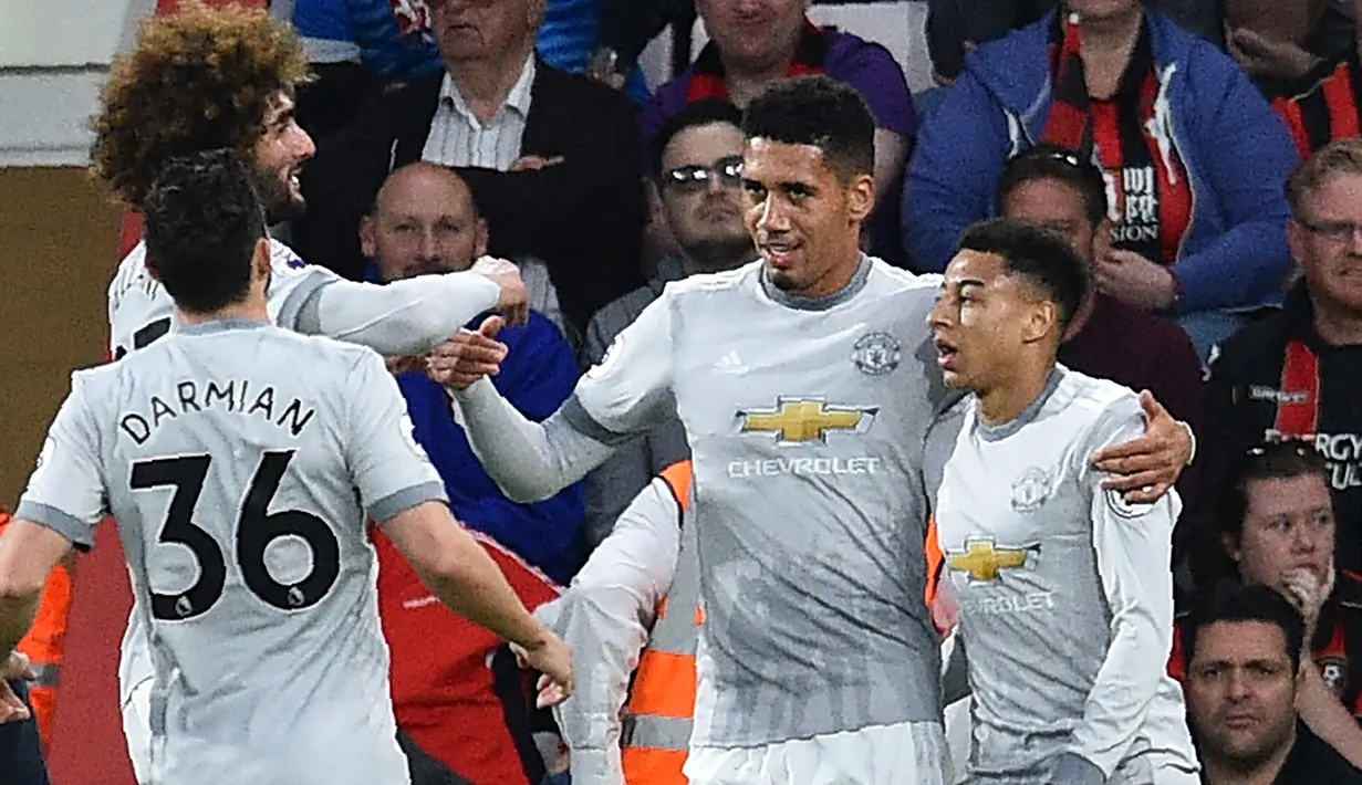 Bek Manchester United, Chris Smalling (kedua kanan) melakukan selebrasi bersama rekan-rekannya usai mencetak gol ke gawang Bournemouth pada pertandingan Liga Inggris di Stadion Vitality, (18/4). MU menang 2-0 atas Bournemouth. (AFP Photo/Glyn Kirk)