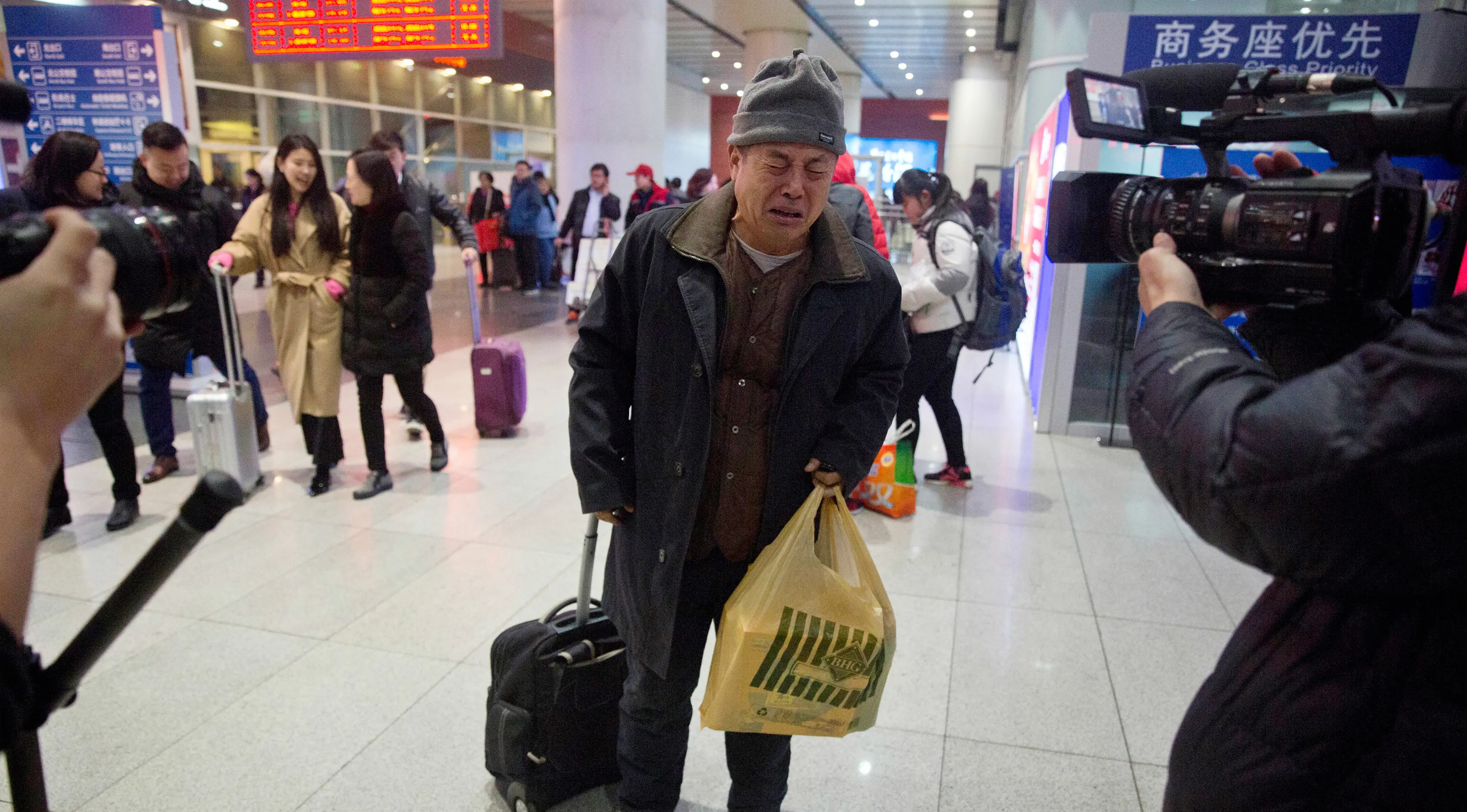 Wen Wanchang menangis saat tiba di stasiun kereta api di Beijing, China (18/1). Kelompok pendukung keluarga MH370, mengatakan pencarian harus terus dilakukan dan diperluas ke arah utara dari tempat pencarian saat ini. (AP Photo/Ng Han Guan)
