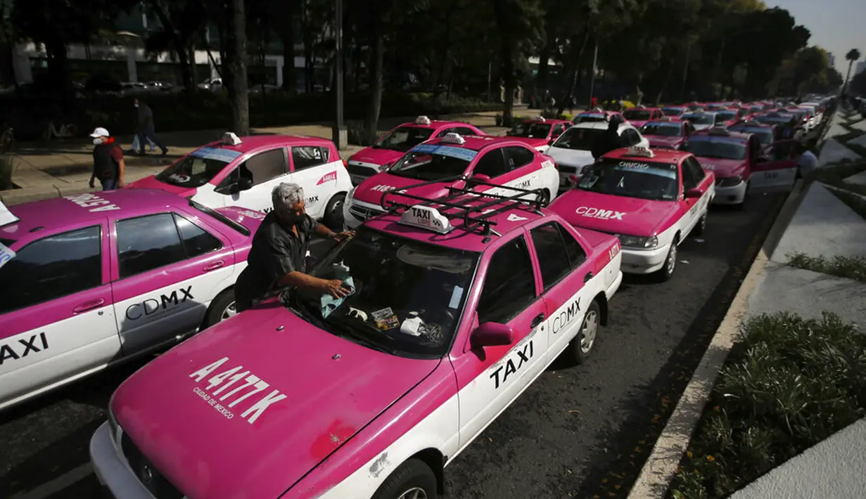 Sopir taksi memblokir bundaran monumen Angel of Independence di Jalan Paseo de la Reforma, Mexico City, Meksiko, Senin (12/10/2020). Para sopir taksi menuntut kondisi yang sama dengan layanan transportasi online, seperti peraturan dan biaya pemerintah. (AP Photo/Fernando Llano)