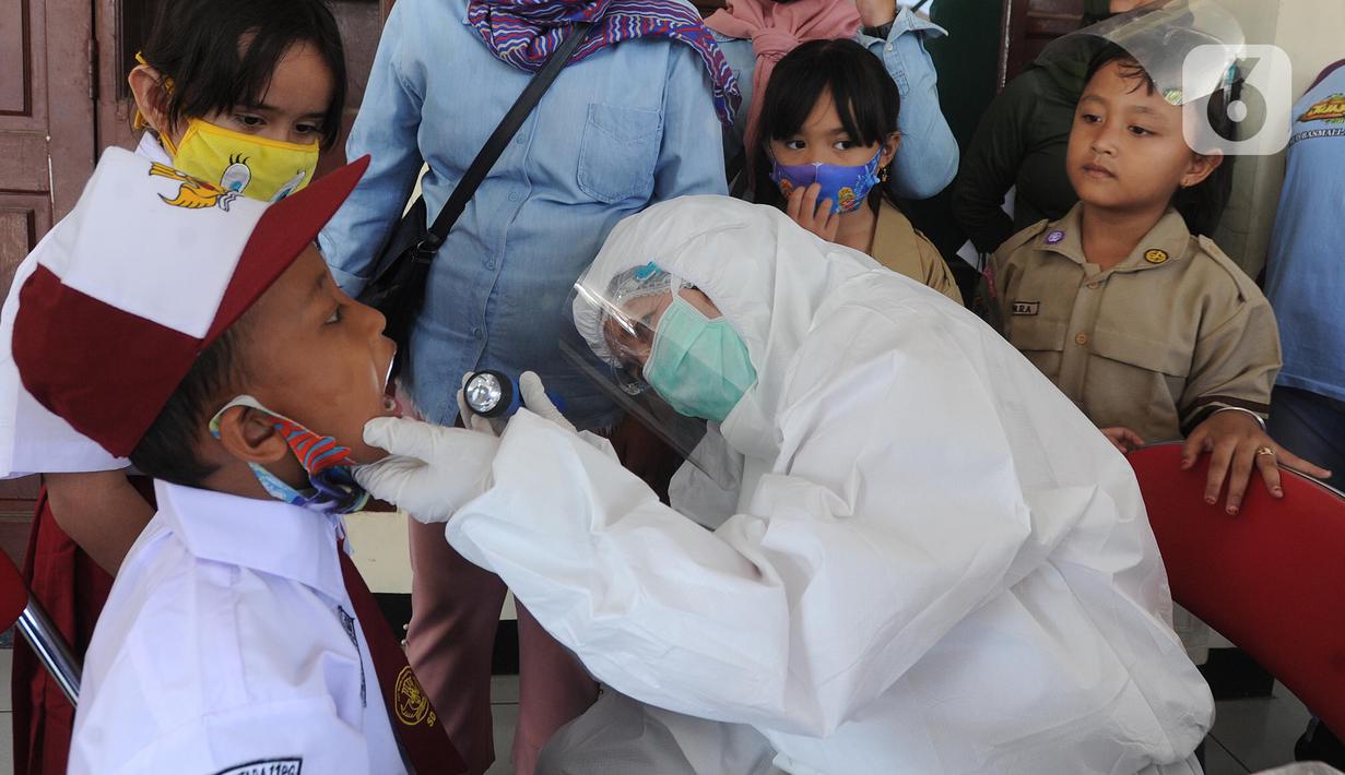 Tim medis puskesmas memeriksa murid Sekolah Dasar Negeri pada lingkungan Kecamatan Kebayoran Lama di GOR Kebayoran Lama, Jakarta, Rabu (26/08/2020). Kegiatan ini bagian dari bulan imunisasi anak sekolah dan juga pemeriksaan kesehatan menyeluruh kepada murid SDN di DKI. (merdeka.com/Arie Basuki)