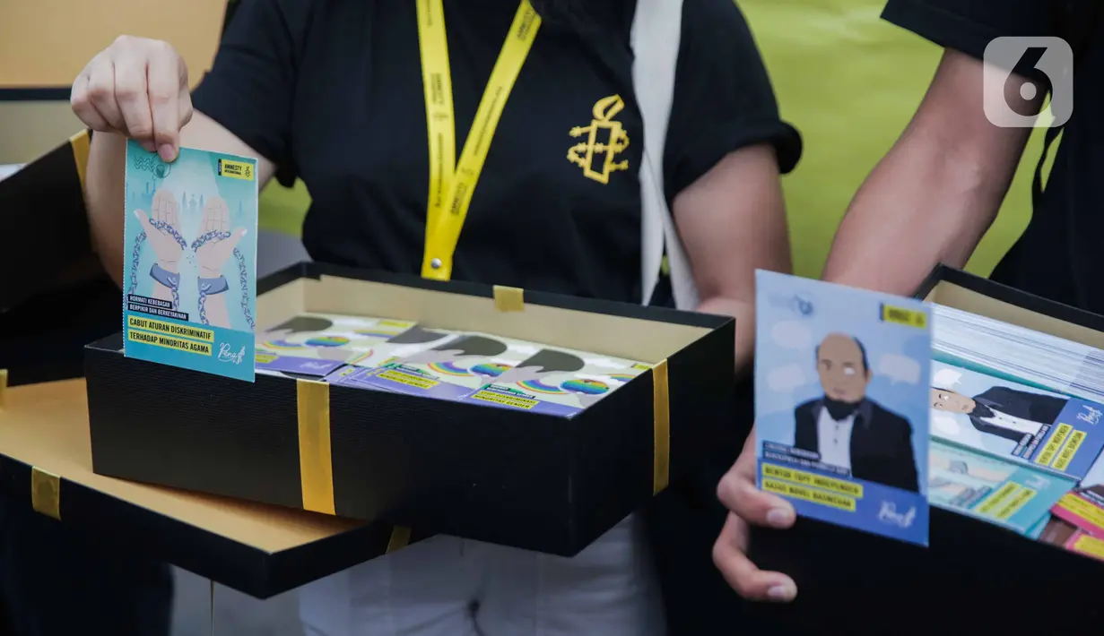 Aktivis yang tergabung dalam Amnesty Internasional Indonesia membawa bingkisan saat menggelar aksi di depan Istana Negara, Jakarta, Selasa (10/12/2019). Aksi tersebut digelar untuk memperingati Hari HAM Sedunia 2019. (Liputan6.com/Faizal Fanani)