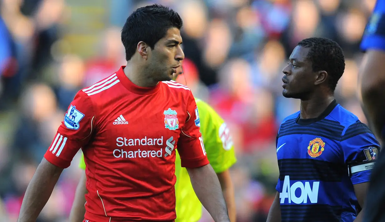 Persaingan antara Luis Suarez dan Patrice Evra paling dikenang oleh pendukung MU. Perbuatan rasisme Suarez terhadap Evra membuat dirinya mendapatkan larangan bermain sebanyak delapan pertandingan. Sejak saat itu rivalitas keduanya masih terus diingat sampai saat ini. (AFP/Andrew Yates)