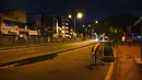 Seorang pria menyapu jalan kosong selama penguncian atau lockdown nasional yang diberlakukan di Kolombo, Sri Lanka, Senin (23/8/2021).  Pemerintah Sri Lanka menerapkan lockdown selama 10 hari ketika kasus corona Covid-19 kembali meningkat. (Ishara S. KODIKARA / AFP)