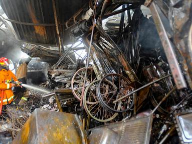 Petugas pemadam kebakaran Pemerintah Kota Depok memadamkan sisa api kebakaran lapak rongsok di Jalan Karet, Beji, Kota Depok, Jawa Barat, Selasa (5/12/2023). Sekitar 10 unit mobil pemadam kebakaran dikerahkan untuk memadamkan kebakaran yang terjadi di belakang Margo City tersebut. (merdeka.com/Arie Basuki)