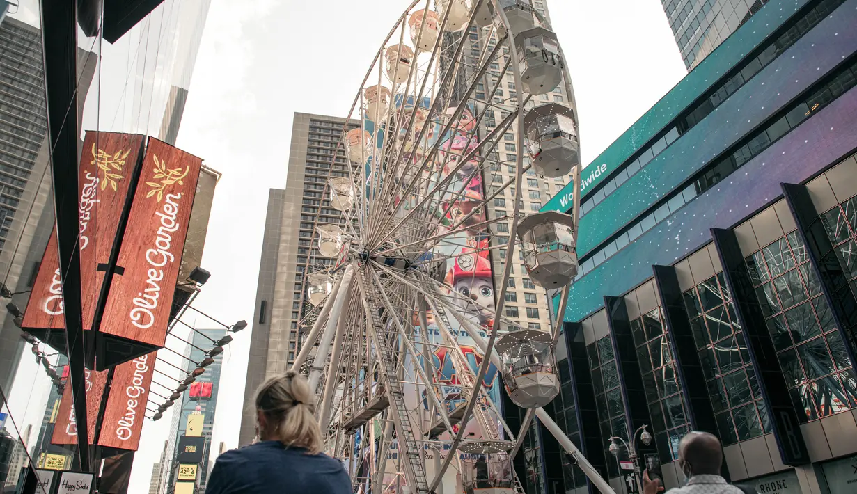 Biangalala raksasa yang baru dibuka berputar di Times Square, Manhattan, New York City, Rabu (25/8/2021). Bianglala setinggi 110 kaki atau setara dengan 11 lantai dari atas tanah tersebut beroperasi dari 25 Agustus hingga 12 September. (Scott Heins/Getty Images/AFP)