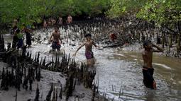 Orang-orang mengambil bagian dalam tradisi mandi lumpur yang dikenal sebagai Mebuug-buugan di Desa Kedonganan, Bali, 4 Maret 2022. Mebuug-buugan diadakan sehari setelah Nyepi yang bertujuan untuk menetralkan sifat buruk. (SONY TUMBELAKA/AFP)