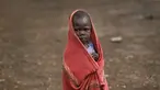 Seorang anak pengungsi muda Sudan Selatan berlindung dari rintik hujan di pemukiman pengungsi Bidi Bidi, Uganda, Selasa (6/6). Bidi Bidi adalah pemukiman pengungsi terbesar di dunia yang menampung pengungsi Sudan Selatan. (AP Photo / Ben Curtis)