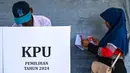 Pemilihan Kepala Daerah (Pilkada) menjadi pesta demokrasi kedua yang berlangsung di Indonesia pada tahun 2024, setelah sebelumnya, pada Februari lalu dilaksanakan Pemilihan Umum Legislatif dan Pemilihan Presiden/Wakil Presiden. Tampak dalam foto, seorang pemilih memeriksa surat suaranya sebelum memberikan suaranya dalam pemilihan kepala daerah di Darul Imarah, pinggiran Banda Aceh, pada 27 November 2024. (CHAIDEER MAHYUDDIN/AFP)