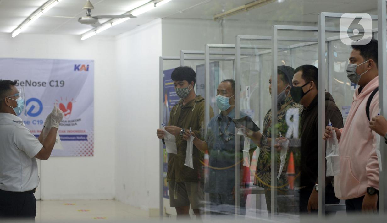 Petugas mengajari calon penumpang untuk tes COVID-19 dengan GeNose C19 di Stasiun Pasar Senen, Jakarta, Selasa (23/2/2021). PT KAI memberikan pelayanan tes COVID-19 dengan GeNose C19 bagi calon penumpang kereta jarak jauh untuk memutus rantai penyebaran virus corona. (merdeka.com/Imam Buhori)