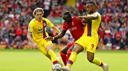 Pemain Liverpool Sadio Mane berebut bola dengan pemain Crystal Palace Jordan Ayew (kanan) pada pertandingan Liga Inggris di Stadion Anfield, Liverpool, Inggris, Sabtu (18/9/2021). Liverpool menang telak 3-0. (AP Photo/Jon Super)