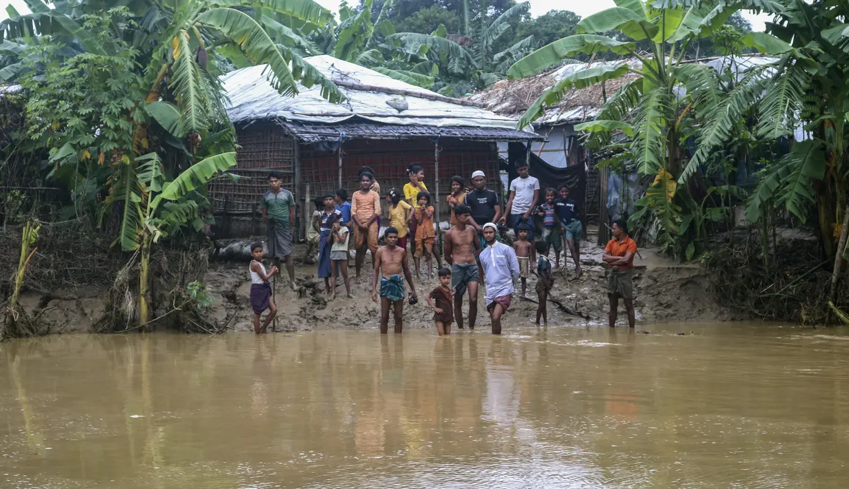 Pengungsi Rohingya memandangi air banjir menyusul hujan deras di kamp pengungsi Rohingya di Kutupalong, Bangladesh (28/7/2021). (AP Photo/ Shafiqur Rahman)
