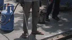 Para pekerja memperbaiki aspal di flyover Kemayoran yang mengalami kerenggangan, Jakarta, Sabtu (5/1). Hal itu disebabkan rusaknya sambungan celah sambungan alias expansion joint. (Merdeka.com/Imam Buhori)