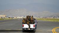 Anggota pasukan khusus Taliban Badri 313 mengendarai kendaraan di landasan pacu Bandara Internasional Hamid Karzai, Kabul, Afghanistan, 31 Agustus 2021. Taliban menguasai Bandara Kabul setelah Amerika Serikat menarik semua pasukannya dari Afghanistan. (WAKIL KOHSAR/AFP)