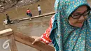 Warga menaiki eretan untuk menyeberangi Kali Ciliwung, Jakarta, Senin (30/11). Tidak adanya fasilitas jembatan menyebabkan warga memilih eretan sebagai sarana penyeberangan sehari-hari, meskipun dengan kondisi seadanya. (Liputan6.com/Immnuel Antonius)