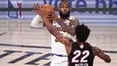Pebasket Los Angeles Lakers, LeBron James, berusaha melewati pebasket Miami Heat, Jimmy Butler, pada laga Gim ketiga Final NBA, Senin (5/10/2020). Miami Heat menang dengan skor 115-104. (AP Photo/Mark J. Terrill)