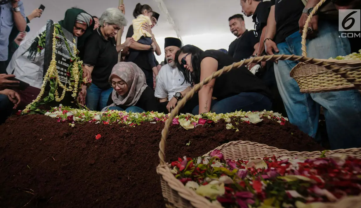 Komedian Indro Warkop bersama anak-anaknya memandangi pusara istrinya, Nita Octobijanthy saat dimakamkan di TPU Tanah Kusir, Jakarta, Rabu (10/10). Mata berkaca-kaca dan raut wajah sedih terlihat dari Indro Warkop. (Liputan6.com/Faizal Fanani)