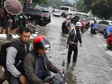 Sejumlah pengendara menerobos banjir yang merendam kawasan Gambir, Jakarta, Kamis (15/2). Banjir tersebut mengakibatkan jalan di sekitar lokasi terpaksa ditutup karena tidak bisa dilalui kendaraan bermotor. (Liputan6.com/Immanuel Antonius)