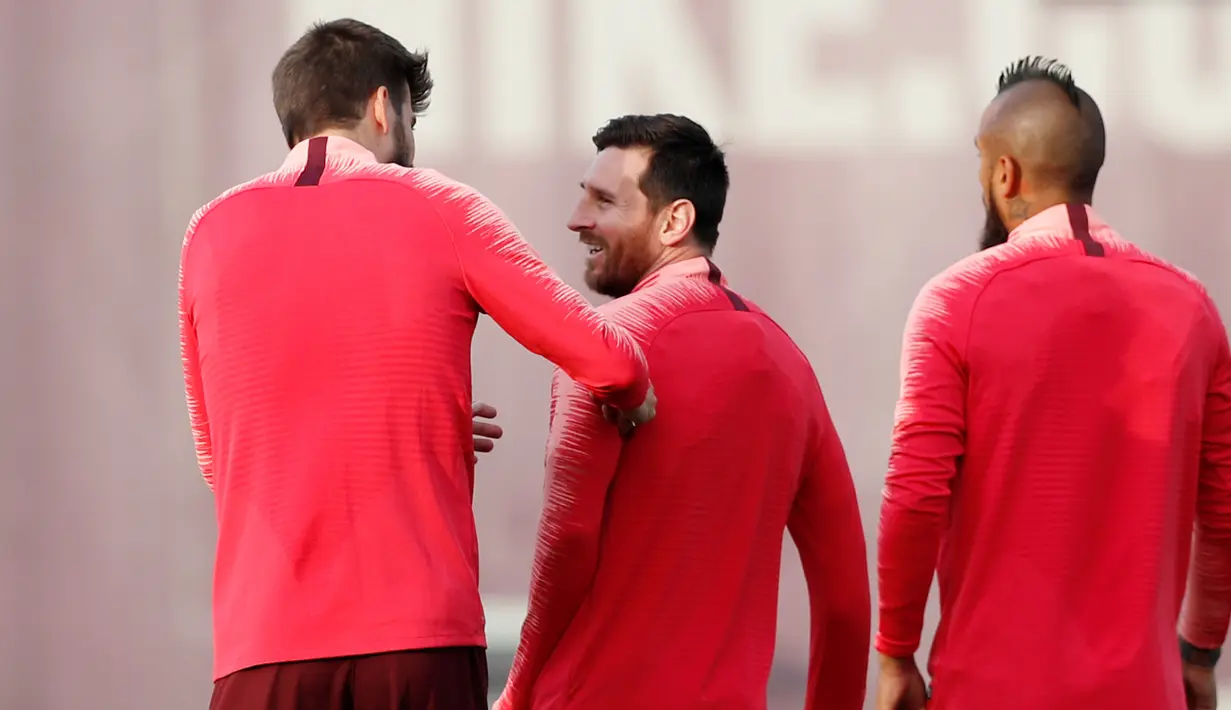 Pemain Barcelona, Lionel Messi (tengah) berbincang dengan Gerard Pique (kiri) saat latihan bersama jelang menghadapi Manchester United (MU) pada leg kedua babak perempat final Liga Champions 2018/19 di Sant Joan Despi, 15 April 2019. Barcelona akan menjamu MU di Camp Nou. (REUTERS/Albert Gea)