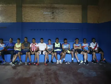 Striker klub divisi dua Resistencia, Nicolas Caballero (keempat kanan) beristirahat di ruang ganti klub di Paraguay, 2 Februari 2021. Caballero (32) yang lebih dari setahun belum dibayar oleh klub, kini memiliki kios barbekyu di pinggir jalan untuk bertahan hidup selama pandemi. (AP/Jorge Saenz)