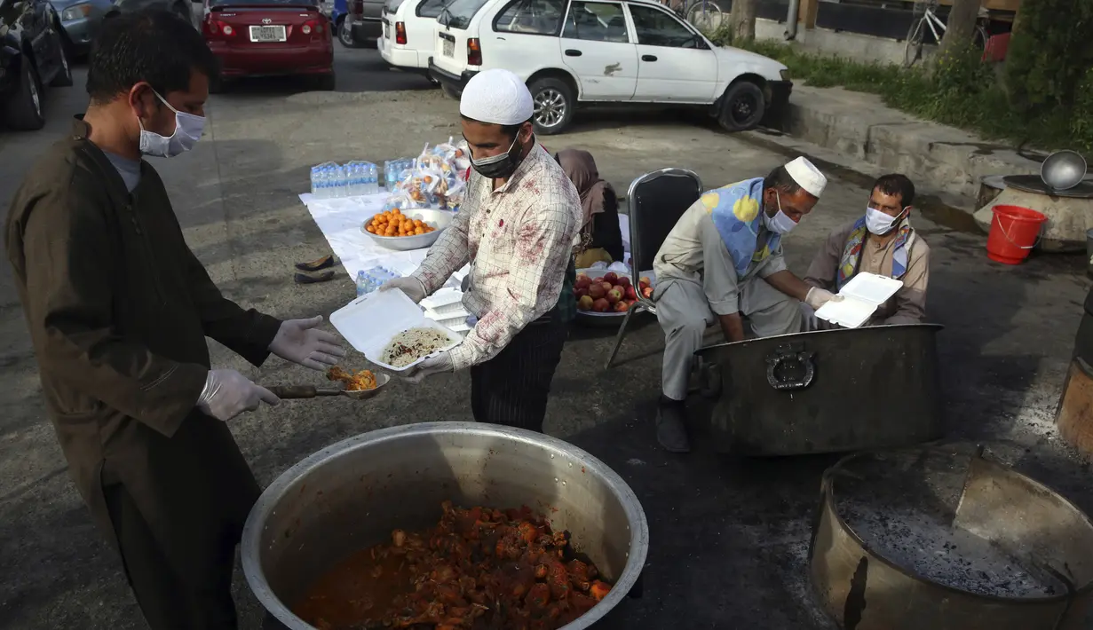 Sukarelawan menyiapkan makanan berbuka puasa gratis untuk orang-orang yang membutuhkan selama bulan puasa suci Ramadan di Kabul, Afghanistan, Kamis (7/5/2020). Muslim di seluruh dunia melewati Ramadan tahun ini di tengah pandemi virus corona COVID-19 dan PHK. (AP Photo/Rahmat Gul)