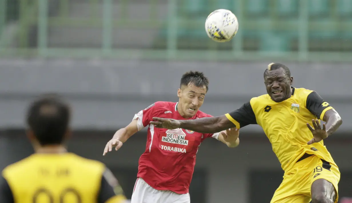 Striker Bhayangkara FC, Herman Dzumafo, duel udara dengan bek Semen Padang, Shukurali Pulatov, pada laga Piala Presiden 2019 di Stadion Patriot, Jawa Barat, Minggu (3/3). Bhayangkara FC menang 4-2 atas Semen Padang. (Bola.com/M Iqbal Ichsan)
