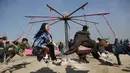 Anak-anak bermain ayunan selama perayaan Nowruz, Tahun Baru Persia, di Kabul, Afghanistan, (21/3). Nowruz dirayakan pada hari pertama musim semi di negara-negara termasuk Afghanistan, Tajikistan, dan Iran. (AP Photo/Rahmat Gul)