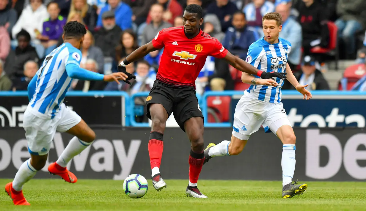 Gelandang Manchester United, Paul Pogba berusaha mengontrol bola dibayangi oleh pemain Huddersfield Town pada pekan ke-37 Liga Inggris di John Smith's Stadium, Minggu (5/5/2019). MU gagal ke Liga Champions musim depan setelah ditahan Huddersfield Town dengan skor 1-1. (Anthony Devlin/PA via AP)
