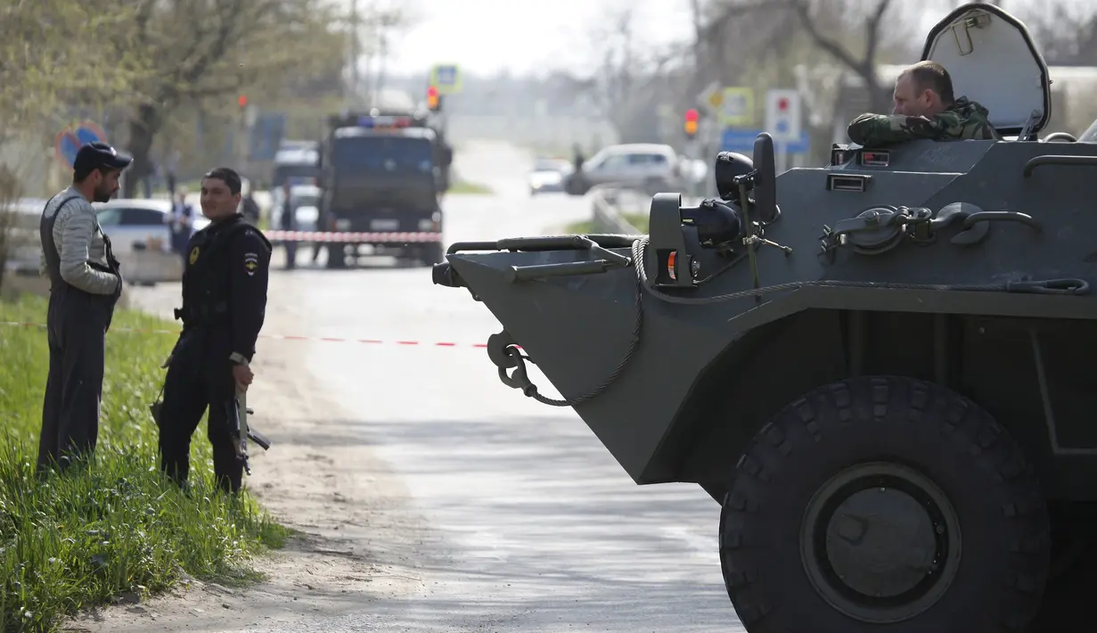 Aparat keamanan Rusia berada di dalam kendaraan lapis baja saat patroli usai serangan bom bunuh diri di Stavropol, Rusia (11/4). Serangan teror tersebut, terdapat ada tiga ledakan bom bunuh diri. (REUTERS/Eduard Korniyenko)