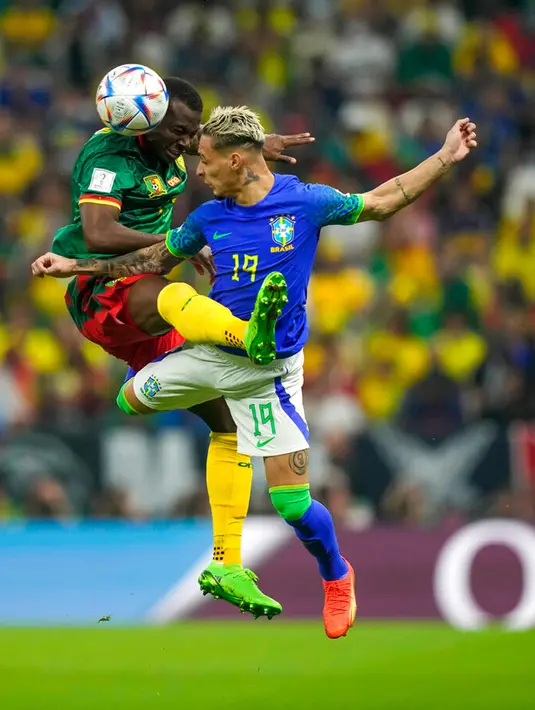 Pemain Kamerun Tolo Nouhou (kiri) berebut bola udara dengan pemain Brasil Antony (kanan) pada pertandingan sepak bola Grup G Piala Dunia 2022 di Stadion Lusail, Lusail, Qatar, 2 Desember 2022. Kamerun menang 1-0 atas Brasil, namun tetap tak lolos ke babak selanjutnya. (AP Photo/Frank Augstein)