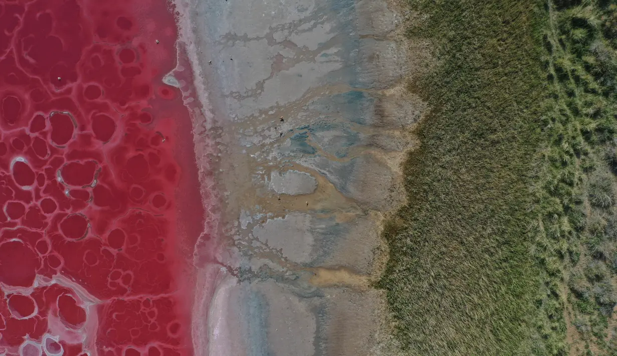 Foto dari udara yang diabadikan saat malam hari pada 30 Mei 2020 ini menunjukkan Danau Daghtu di Gurun Badain Jaran, Daerah Otonom Mongolia Dalam, China utara. Menurut pemandu wisata setempat, warna merah muda pada Danau Daghtu disebabkan oleh mineral garam di dasar danau tersebut. (Xinhua/Xu Qin)