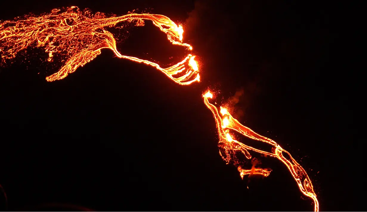 Lava mengalir dari gunung berapi Fagradalsfjall yang meletus, sekitar 40 km dari ibu kota Islandia, Reykjavik, pada Jumat (19/3/2021). Aliran lava bisa terlihat keluar dari retakan di tanah dalam video yang direkam oleh helikopter penjaga pantai Islandia (IMO). (Icelandic Coast Guard/AFP)