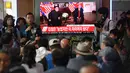 Calon penumpang dan awak media melihat berita pertemuan Presiden AS Donald Trump dan pemimpin Korea Utara Kim Jong-un di sebuah stasiun kereta api Seoul, Selasa (12/6). Untuk pertama kalinya dalam sejarah, Trump dan Kim bertemu. (AFP PHOTO/Jung Yeon-je)