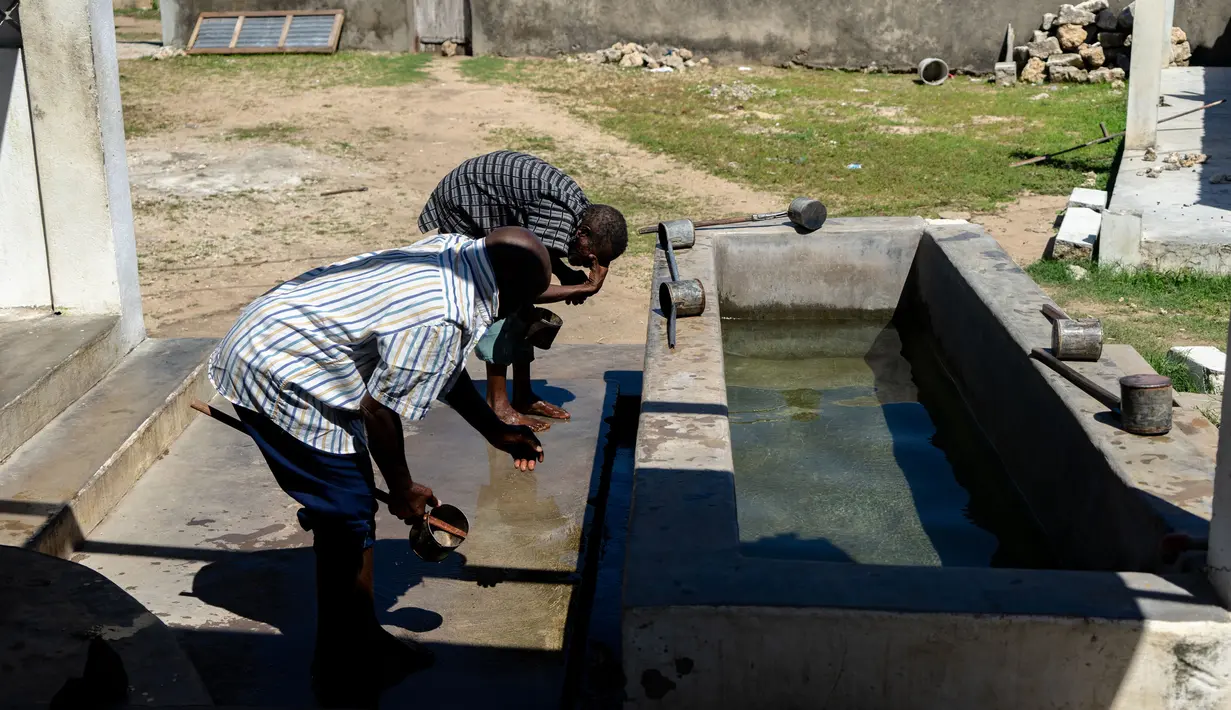 Pria muslim mengambil air untuk wudhu untuk melaksanakan salat selama bulan Ramadan di desa Kumwamba, Pulau Ibo, 14 Mei 2019. Umat Islam di Mozambik melalui bulan Ramadan dengan badai yang menyebabkan sebagian besar masjid hancur dan persediaan makanan sangat terbatas (Zinyange Auntony/AFP)
