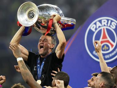 Pelatih PSG, Luis Enrique mengangkat trofi Liga Champions 2024/2025 setelah berhasil mengalahkan Inter Milan dalam laga final yang berlangsung di Allianz Arena, Munchen, Jerman, Minggu (01/06/2025) dini hari WIB. (AP Photo/Luca Bruno)