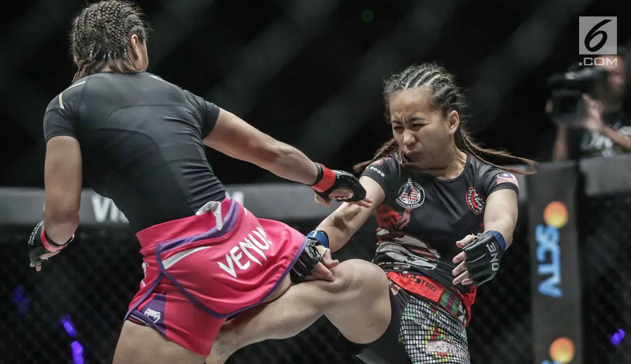Petarung putri Indonesia, Priscilla Hertati Lumban Gaol (kiri) dan  petarung putri Malaysia, Audreylaura Boniface (kanan) melakukan tendangan saat berlaga pada partai pertama One Championship di Jakarta, Sabtu (20/1). (Liputan6.com/Faizal Fanani)