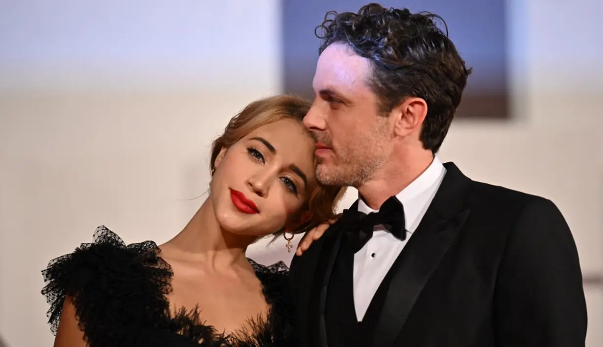 Aktor Amerika Serikat Casey Affleck dan aktris Amerika Serikat Caylee Cowan saat tiba pada pemutaran film 'Dreamin' Wild' di Venice Film Festival 2022 di Lido, Venesia, Italia, di Lido di Venezia di Venesia, Italia, 7 September 2022. Sama seperti Casey Affleck, Caylee Cowan juga tak ragu memamerkan kemesraannya kepada sang kekasih salah satunya dengan menaruh kepalanya pada bahu Affleck. (Tiziana FABI/AFP)