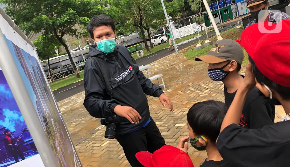 Komunitas “Kelas Jurnalis Cilik” dipandu pewarta foto mengikuti kegiatan tur pameran fotografi bertema 'Ragam Cerita Ibu Kota Sebelum dan Saat Pandemi COVID-19' di Thamrin 10, Jakarta, Minggu (6/12/2020). Pameran diselenggarakan oleh Pewarta Foto Indonesia - Jakarta. (Liputan6.com/Immanuel Anton