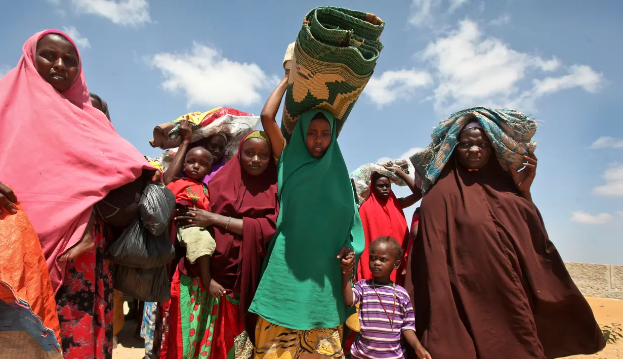 Sejumlah wanita Somalia membawa alas dan perlengkapan lainnya saat mengungsi akibat kekeringan yang melanda kawasannya di daerah Tabelaha di pinggiran Mogadishu, Somalia (30/3). (AP Photo/Farah Abdi Warsameh)