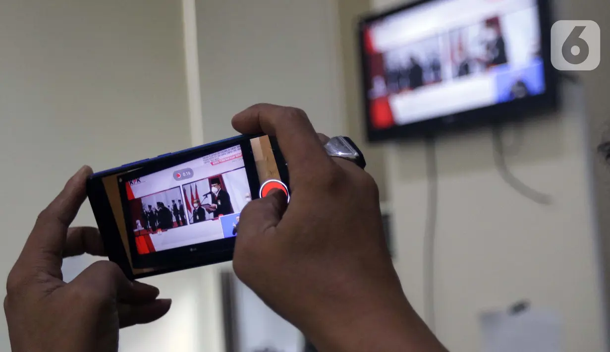 Pewarta merekam prosesi pengambilan sumpah janji jabatan pegawai KPK menjadi Aparatur Sipil Negara di Gedung Merah Putih KPK, Jakarta, Selasa (1/6/2021). Pelantikan 1.271 pegawai KPK menjadi Aparatur Sipil Negara dilakukan secara daring dan luring terbatas. (Liputan6.com/Helmi Fithriansyah)