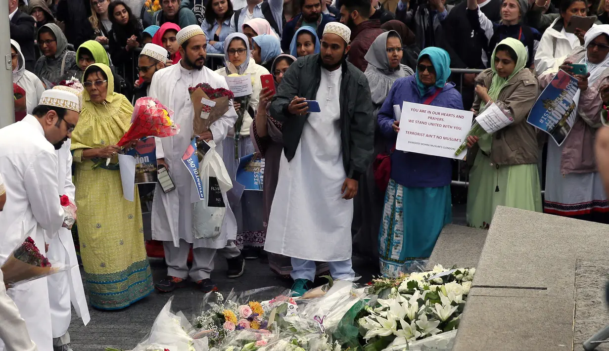 Sejumlah muslim meletakkan karangan bunga di Potters Field Park, London, Senin (5/6). Mereka mengenang dan mendoakan para korban serangan teror di London Bridge dan Borough Market yang menewaskan 7 orang dan melukai puluhan lainnya. (AP Photo/Tim Ireland)