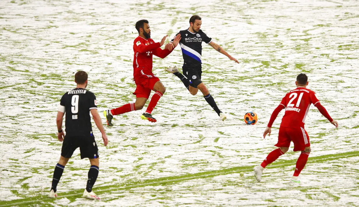 Pemain Arminia Bielefeld Manuel Prietl (tengah kanan) memperebutkan bola dengan pemain Bayern Munchen Eric Maxim Choupo-Moting pada pertandingan Bundesliga di Allianz Arena, Munich, Jerman, Senin (15/2/2021). Laga berakhir dengan skor 3-3. (Adam Pretty/Pool via AP)