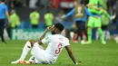 Bek timnas Inggris, Danny Rose terlihat kecewa sambil duduk di lapangan seusai babak semifinal Piala Dunia 2018 melawan Kroasia di Stadion Luzhniki, Rabu (11/7). Rose menyita perhatian lantaran mengenakan kaus kaki yang berlubang. (AFP/Kirill KUDRYAVTSEV)