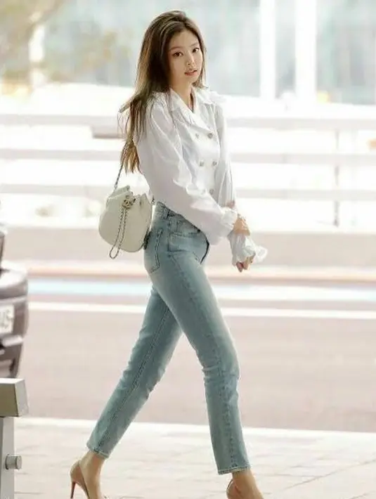 Kombinasi blouse warna putih dengan celana jeans seperti Jennie BLACKPINK memang tak pernah kehilangan zaman. Sepatu high heels pun mempermanis tampilan. (Instagram/niniblink_____).