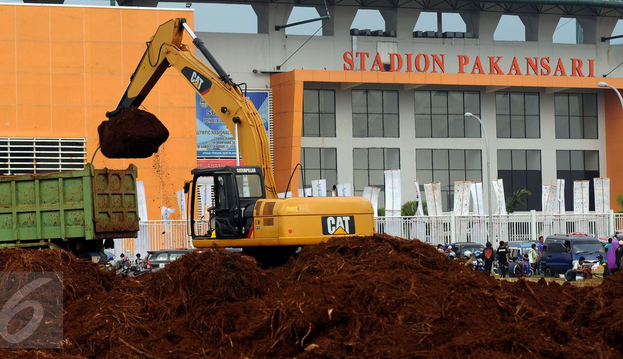 Alat berat melakukan proses pengerukan tanah di luar Stadion Pakansari, Kabupaten Bogor, Minggu (21/8). Jelang pelaksanaan PON XIX Jawa Barat, pembangunan sarana pertandingan di Stadion Pakansari terus dikerjakan. (Liputan6.com/Helmi Fithriansyah)
